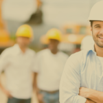 men smiling in hard hats at job site